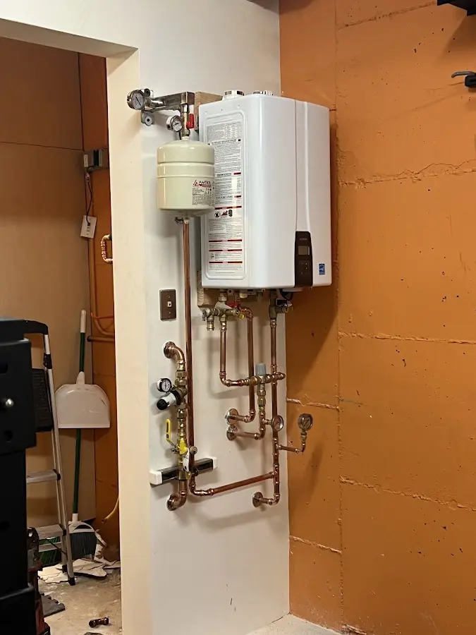 Plumbing technician inspecting water heater connections in Woodburn